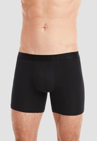 Black cotton boxer briefs with a snug fit, featuring a logo waistband and smooth texture, designed for comfort and support.