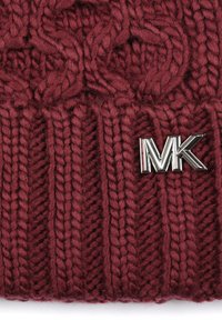 Burgundowy beanie z dzianiny o fakturowanym wzorze oraz srebrnym akcentem z logo "MK" z boku. Miękki, gruby materiał zapewniający ciepło i komfort.