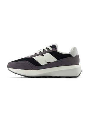 Sort og grå sneaker med hvidt logo og snørebånd, tyk hvid og grå sål, vist fra siden på hvid baggrund.