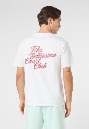 Man facing away wearing a white T-shirt with pink cursive text "Fila Bellissimo Court Club" and light green shorts against a plain background.