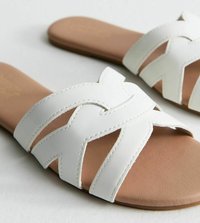 Des sandales blanches à glissière avec un design de sangle tissée, présentant un dessus en synthétique lisse et une semelle intérieure texturée couleur tan. Semelle plate, sans accents en métal.