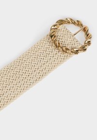 Cintura intrecciata beige con una fibbia circolare in tonalità oro intrecciata. La texture della cintura è liscia con un motivo intrecciato.