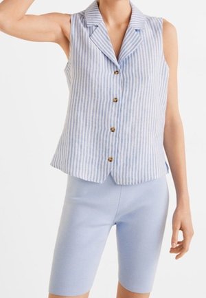 Chemise sans manches à rayures bleues et blanches avec boutons, portée avec un short cintré bleu clair arrivant au genou sur une personne.