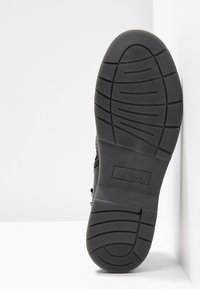 Semelle de chaussure en caoutchouc noir avec des motifs de crampons, taille 37 indiquée, et logo "s.Oliver" embossé sur la zone du talon.
