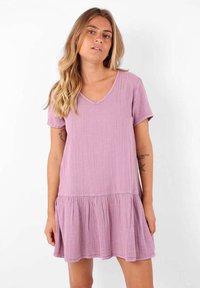 Robe à manches courtes et décolleté en V couleur lavande claire, dotée d'un ourlet à volants superposés et d'une surface texturée. Conception décontractée avec une coupe ample.