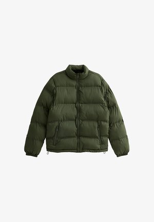 Donkergroene pufferjas, met hoge kraag, ritssluiting aan de voorkant en twee zijzakken. Zachte, gequiltte textuur met elastische manchetten.