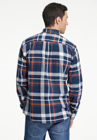 Camicia flanella da uomo con motivo a quadri blu, bianco e arancione, maniche lunghe, colletto button-down e orlo curvo.