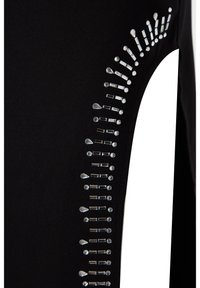 Leggings noirs avec un design sur le côté constitué de strass argentés et transparents disposés en diverses formes le long de la couture pour apporter du détail et de la texture.