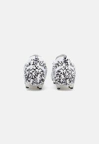 Scarpe da football con un design digitale a pixel bianco e nero, realizzate in materiale sintetico con una forma a taglio basso e tacchetti sagomati.