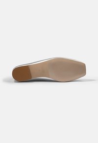 Sole de pantof de culoare argintie, cu o formă ascuțită, textură cauciucată și o talpă anti-alunecare de culoare maro deschis. Include gravura mărcii și mărimea.