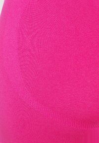 Fuchsia naadloze top gemaakt van rekbare stof, met een gladde textuur en een getailleerd ontwerp met subtiele ribbels.