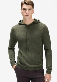 Olivgrön hoodie gjord av ett mjukt stickat material. Har en huva med dragsko, långa ärmar och en framsida kanguroficka.