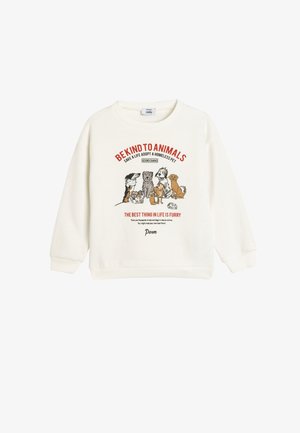 Pull en laine de couleur crème présentant un motif de divers chiens, avec un texte promouvant l'adoption animale. Manches et ourlet côtelés. Matériau en coton doux.