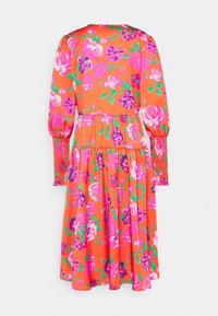 Robe midi orange avec imprimé floral rose et violet, manches longues bouffantes avec poignets smockés, et jupe à volants.