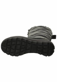 Botas negras con una parte superior acolchada y con relleno, notable forro de piel sintética y una suela de goma texturizada con profundos surcos y una lengüeta.