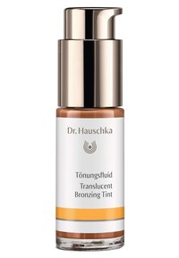 Dr. Hauschka Translucent Bronzing Tint in a clear glass bottle with a gold pump lid, featuring white and orange branding details.