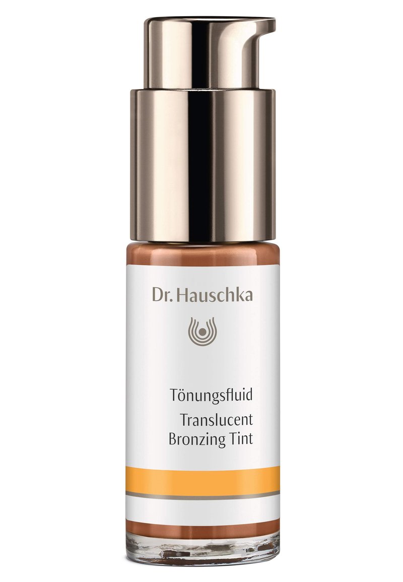 Dr. Hauschka Translucent Bronzing Tint in a clear glass bottle with a gold pump lid, featuring white and orange branding details.