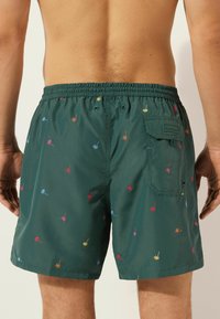Groene zwemshorts van lichtgewicht stof, met multicolore bloemenborduurwerk en een elastische tailleband met een zijzak.