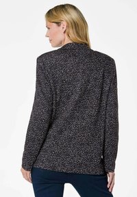 Zwarte blazer met een gestructureerd patroon met witte en paarse spikkels. Het heeft een kraag en lange mouwen, getoond vanaf de achterkant.