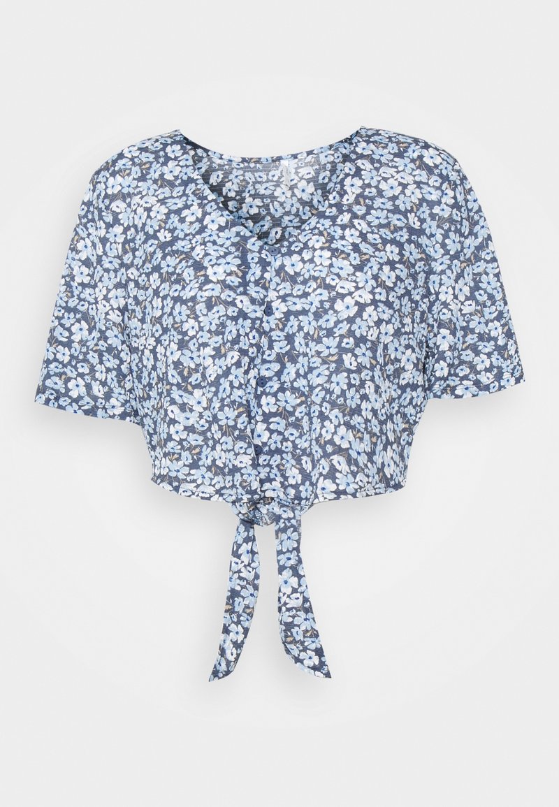 Haut court bleu à fleurs avec un col en V, des manches courtes et un lien à nouer à l'avant. Présente des fleurs blanches et bleu clair sur un fond bleu foncé.