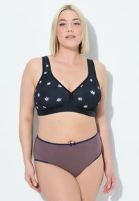 Sujetador inalámbrico negro con bordado floral y diseño en forma de V, combinado con braguitas marrones de tiro alto con un acento de cinta.