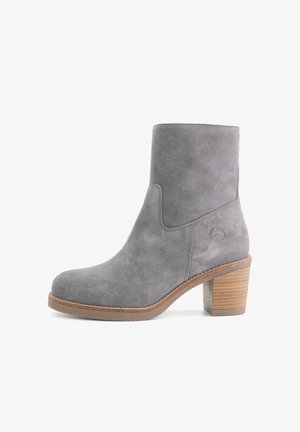 Grijze suède enkellaars met een ronde neus, een zijnaad en een gestapeld houten hak met gestructureerde details.