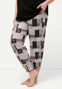 Gemusterte Hosen mit einer Mischung aus geometrischen und floralen Designs in Beige, Schwarz und Rosa. Lockere Passform mit elastischen Bündchen an den Knöcheln.