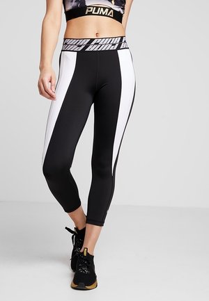 Leggings capri à motifs noir et blanc avec une taille haute. Fabriqués en tissu extensible, présentant des panneaux blancs sur les côtés et des détails de logo.