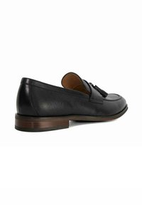 Black leather shoe with textured surface, sleek design, rounded toe, and a low wooden heel. Features a decorative tassel on the upper.