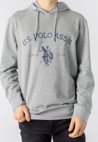 Šedá mikina s kapucí z měkké látky. Na přední straně je tmavě modrý potisk s pólo scénou a textem „U.S. POLO ASSN. SINCE 1890.“ Nastavitelná kapuce.