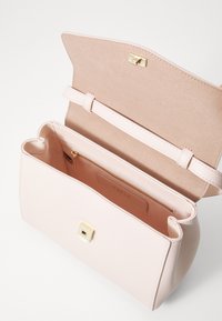 Pink læderhåndtaske med en glat overflade, guld hardware, en magnetisk lukning og et rummeligt indre med en lynlås lomme.