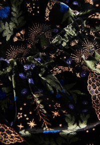 Melnas samta audums ar ziedu un zvaigžņu rakstu zeltā, zilā un zaļā krāsā, ar saburzītas detaļas, lai piešķirtu tekstūru.