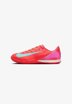 Chaussure de sport rouge vif avec un swoosh Nike bleu clair, des détails rayés roses et blancs au talon, et un design à lacets sur fond blanc.