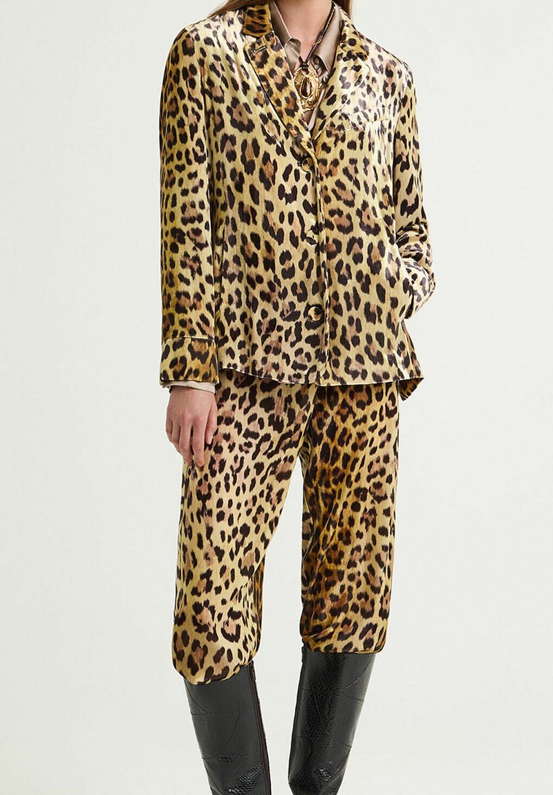 Set di pigiama in raso con stampa leopardata, composto da una giacca con bottoni e pantaloni dalla vestibilità ampia. Presenta una finitura lucida e un colletto classico.