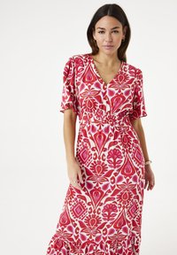 Rode en roze patroon midi-jurk met korte pofmouwen, een V-hals en elastische taille, met een gerimpelde zoom en bloemmotieven.