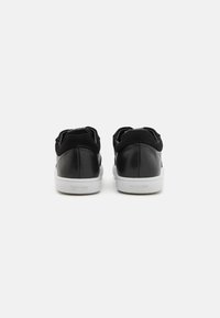 Sneaker in pelle nera e suede con suola in gomma bianca liscia. Caratterizzati da un colletto imbottito e un design minimalista, con logo del marchio sul tallone.