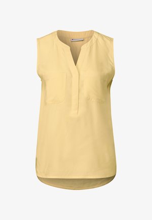 Ärm-lös gul blus med V-halsringning, två bröstfickor och en rundad nerton. Tillverkad av lättviktig tyg med en mjuk yta.