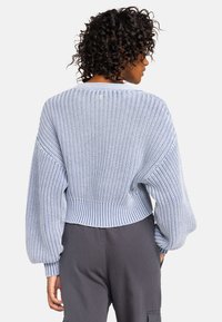 Geknipte blauwe gebreide trui met een gestructureerd patroon, ballonsleeves en een ribgebreide rand; ontworpen met een knoopdetail aan de achterkant.