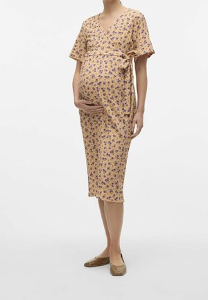 Sukienka kopertowa ciążowa w jasnym pomarańczowym kolorze z fioletowym kwiatowym wzorem. Posiada krótkie rękawy, dekolt w serek oraz wiązanie w talii.