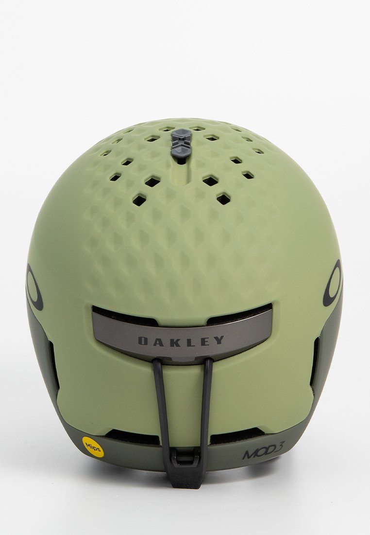 Kask Oakley MOD3 w matowej oliwkowej zieleni z otworami wentylacyjnymi, technologią MIPS i zaokrąglonym kształtem. Srebrny akcent z przodu.