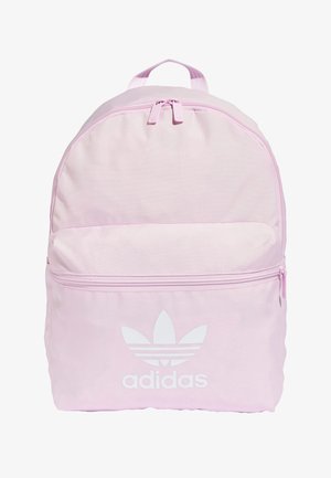 Jasnoróżowy plecak z poliestru z górnym uchwytem, posiadający przednią kieszeń na zamek błyskawiczny oraz białe logo Adidas. Gładka tekstura i zaokrąglony kształt.