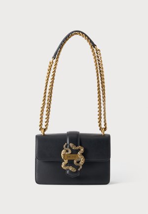 Bolso de hombro de cuero negro con cierre doble de serpiente dorada y cadena dorada retorcida.