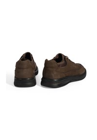 Bruine suede schoenen met een ronde neus, lage hak en zwarte rubberen zool, voorzien van veters en subtiele stiksels op de bovenkant.