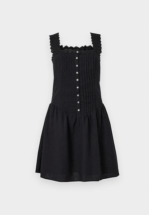 Robe noire sans manches avec fermeture boutonnée à l'avant, bretelles garnies de dentelle, corsage plissé et jupe froncée sur fond uni.