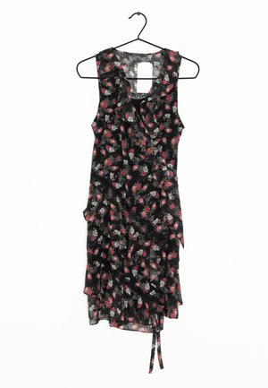 Schwarzes ärmelloses Wickelkleid mit pink-weißem Blumenmuster, Rüschen-Details und einer Bindeschleife an der Seite, hängend an einem schwarzen Drahtbügel.