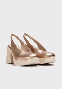 Zapatos de slingback en bronce, con una parte superior metálica texturizada, puntera redondeada y un grueso tacón de plataforma en crema.