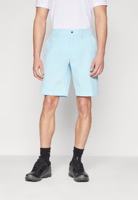 Light blue shorts with a flat front and a single button closure, made of a smooth fabric, paired with black shoes and socks.
