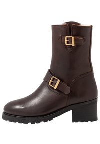 Hnědé kožené kotníkové boty s kulatou špičkou, dvěma nastavitelnými pásky s zlatými sponami a strukturovanou černou gumovou podrážkou.