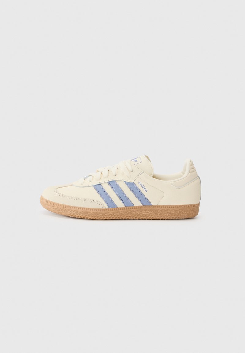 Cremefarbene Sneaker mit hellblauen Streifen und "Samba"-Schriftzug. Verfügt über eine strukturierte Gummi-Sohle und ein glattes Leder-Obermaterial.