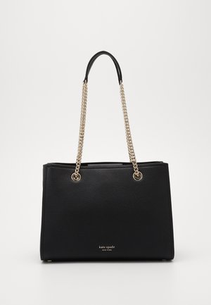 Czarna skórzana torebka z uchwytami z złotego łańcuszka i małym logo "kate spade new york" umieszczonym centralnie blisko dołu.